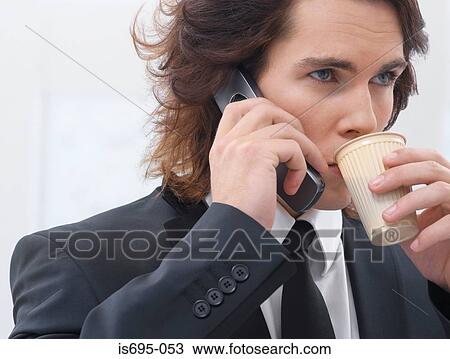 Stock Image - Businessman using a cellular telephone. Fotosearch