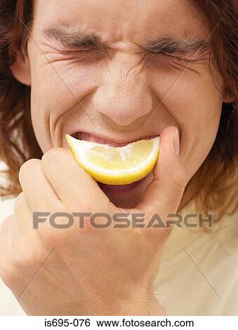 Man biting a slice of lemon View Large Photo Image Stock Photograph - Man biting a slice of lemon. Fotosearch