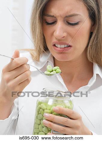 Stock Image - Woman disgusted at broad beans. Fotosearch