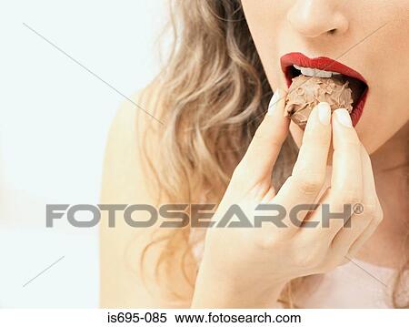 Woman eating a chocolate View Large Photo Image Stock Photography - Woman eating a chocolate. Fotosearch