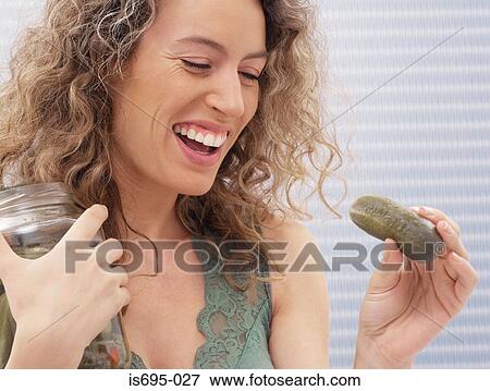 Stock Photo - Woman holding a gherkin. Fotosearch