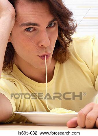 Young man eating spaghetti View Large Photo Image Stock Image - Young man eating spaghetti. Fotosearch