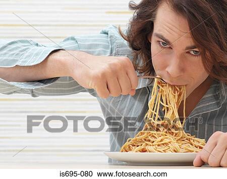 Young man eating spaghetti View Large Photo Image Stock Image - Young man eating spaghetti. Fotosearch