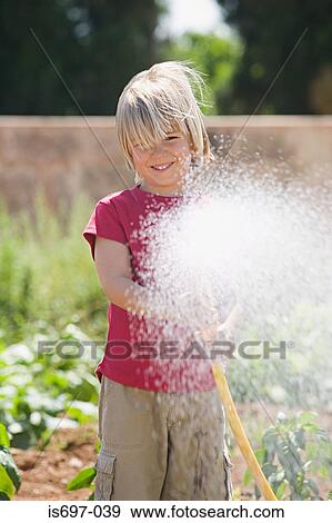 Boy spraying water View Large Photo Image Stock Photo - Boy spraying water. Fotosearch