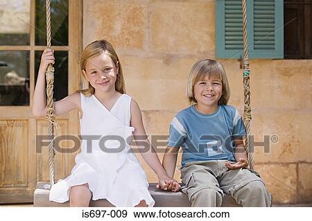 Brother and sister sitting on a swing View Large Photo Image Stock Photo - Brother and sister sitting on a swing. Fotosearch