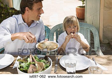 Father and son dining al fresco View Large Photo Image Stock Image - Father and son dining al fresco. Fotosearch