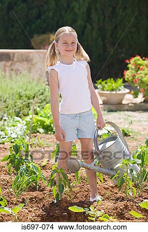 Girl holding watering can View Large Photo Image Picture - Girl holding watering can. Fotosearch