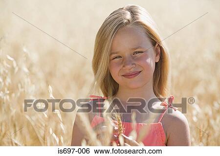 Stock Photograph - Girl in a field of wheat. Fotosearch