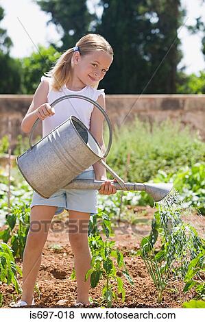 Girl watering plants View Large Photo Image Stock Photo - Girl watering plants. Fotosearch