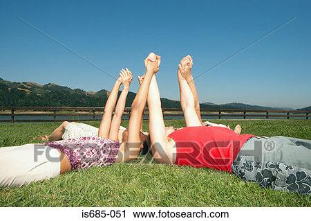 Friends lying down and holding hands View Large Photo Image Stock Image - Friends lying down and holding hands. Fotosearch