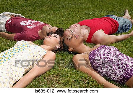 Friends lying on the grass View Large Photo Image Stock Image - Friends lying on the grass. Fotosearch