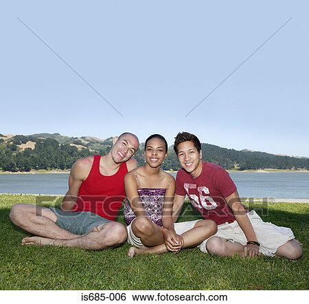Friends sitting near a lake View Large Photo Image Stock Photograph - Friends sitting near a lake. Fotosearch