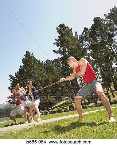 Man playing tug of war with friends View Large Photo Image Picture - Man playing tug of war with friends. Fotosearch