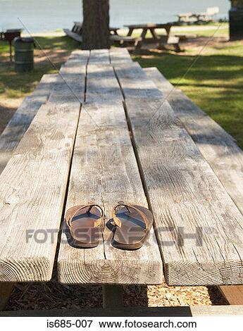Sandals on a picnic bench View Large Photo Image Stock Photo - Sandals on a picnic bench. Fotosearch