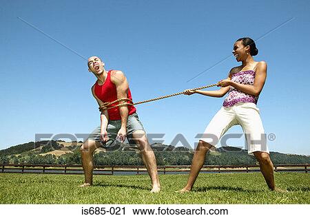 Stock Image - Woman tying rope around man. Fotosearch