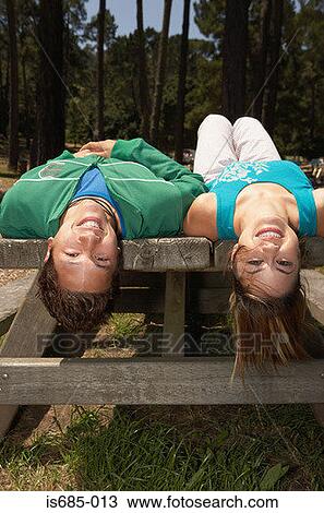 Young couple lying on a picnic table View Large Photo Image Stock Image - Young couple lying on a picnic table. Fotosearch