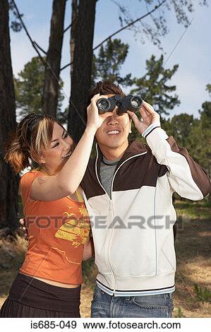 Young couple using binoculars View Large Photo Image Stock Photo - Young couple using binoculars. Fotosearch