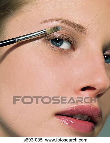 Stock Photography - Woman applying eyeshadow. Fotosearch