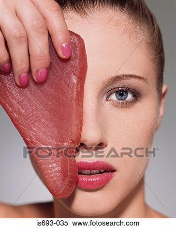 Woman holding tuna steak over her eye View Large Photo Image Stock Photography - Woman holding tuna steak over her eye. Fotosearch