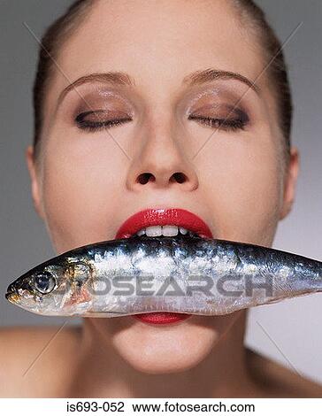 Woman with fish in her mouth View Large Photo Image Stock Image - Woman with fish in her mouth. Fotosearch