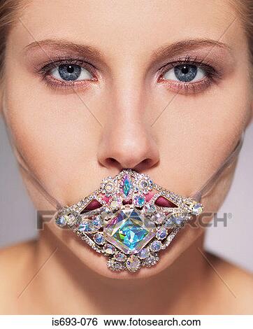 Woman with jewelry over her mouth View Large Photo Image Stock Photograph - Woman with jewelry over her mouth. Fotosearch