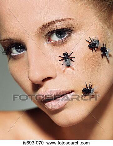 Stock Image - Woman with plastic flies on her face. Fotosearch