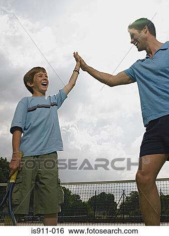 Father and son doing a high five View Large Photo Image Stock Photograph - Father and son doing a high five. Fotosearch