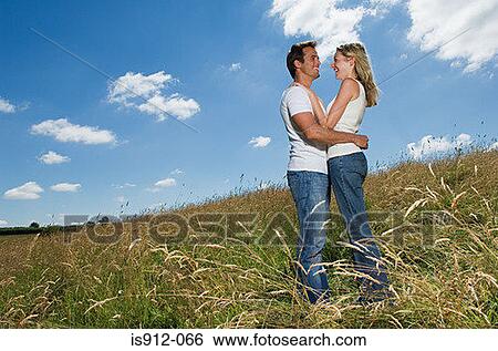 Couple hugging in a field View Large Photo Image Stock Photograph - Couple hugging in a field. Fotosearch