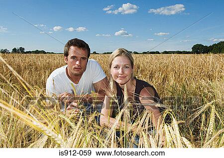 Couple in a field of wheat View Large Photo Image Stock Photo - Couple in a field of wheat. Fotosearch