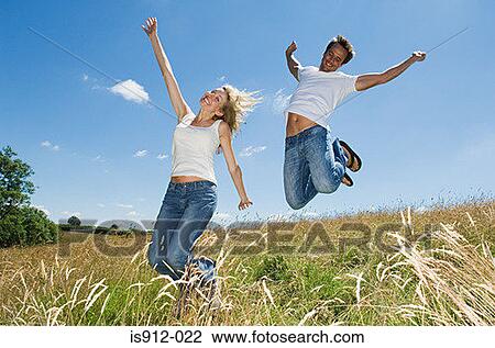 Couple jumping in a field View Large Photo Image Stock Image - Couple jumping in a field. Fotosearch