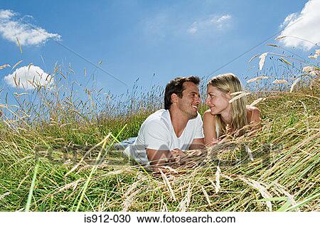 Couple lying in a field View Large Photo Image Stock Image - Couple lying in a field. Fotosearch
