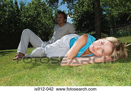 Stock Image - Couple relaxing on the grass. Fotosearch