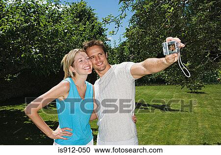 Couple taking a photo of themselves View Large Photo Image Stock Image - Couple taking a photo of themselves. Fotosearch