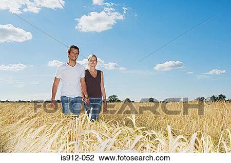 Couple walking in a field of wheat View Large Photo Image Stock Image - Couple walking in a field of wheat. Fotosearch