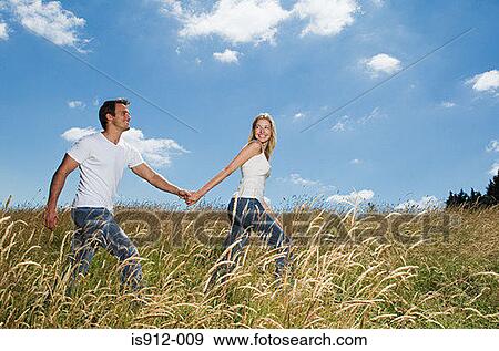 Stock Photo - Couple walking in a field. Fotosearch