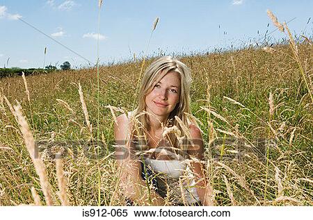 Stock Photography - Woman crouching in a field. Fotosearch