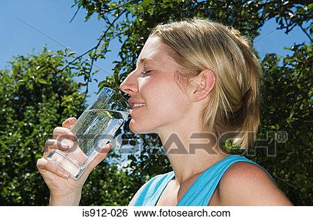 Woman drinking a glass of water View Large Photo Image Stock Photograph - Woman drinking a glass of water. Fotosearch