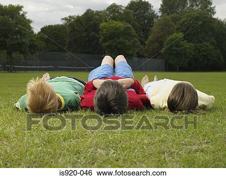 Children lying in the park View Large Photo Image Stock Photograph - Children lying in the park. Fotosearch