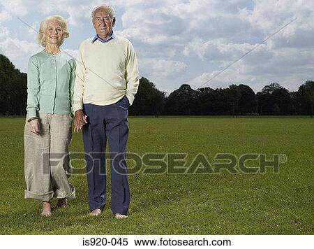 Stock Photography - Elderly couple holding hands in park. Fotosearch