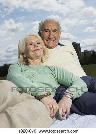 Elderly couple relaxing in a park View Large Photo Image Stock Image - Elderly couple relaxing in a park. Fotosearch