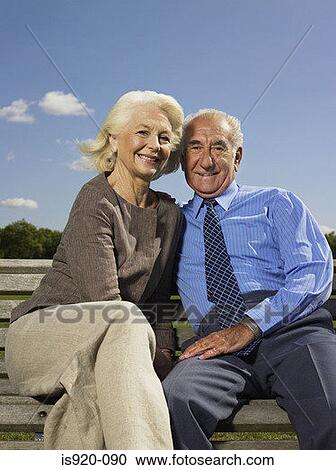 Elderly couple relaxing in a park View Large Photo Image Stock Image - Elderly couple relaxing in a park. Fotosearch
