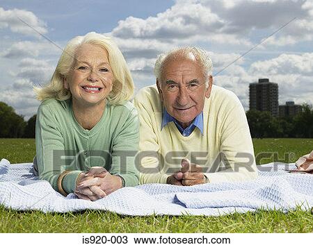 Stock Image - Elderly couple resting in a park. Fotosearch