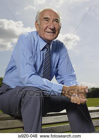 Stock Photo - Elderly man sitting in a park. Fotosearch