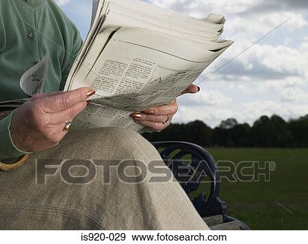 Stock Photo - Elderly woman reading a newspaper. Fotosearch