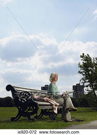 Elderly woman reading in a park View Large Photo Image Stock Image - Elderly woman reading in a park. Fotosearch