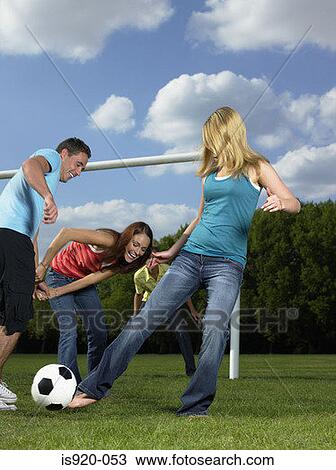 Stock Image - Friends playing football in the park. Fotosearch