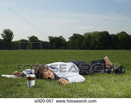 Stock Photo - Male office worker sleeping in a park. Fotosearch