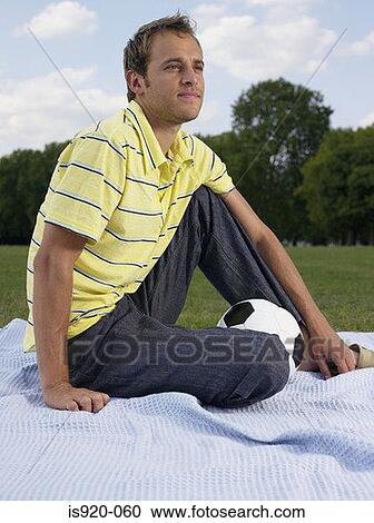 Stock Image - Man sitting in a park. Fotosearch
