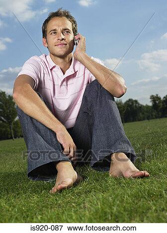 Stock Photo - Man using a cellular telephone in a park. Fotosearch