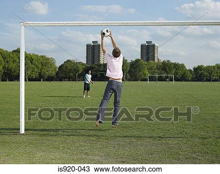 Men playing football in the park View Large Photo Image Stock Image - Men playing football in the park. Fotosearch